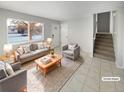 Virtually staged living room with gray sofas and a coffee table at 481 S Lima Cir, Aurora, CO 80012