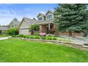 Beautiful home with a lush front yard, mature landscaping, and a stone retaining wall at 2974 E Otero Cir, Centennial, CO 80122