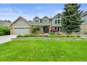 Charming two-story home with well-manicured lawn, mature trees, and beautiful flower beds at 2974 E Otero Cir, Centennial, CO 80122