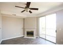 Living room featuring a fireplace, ceiling fan, and sliding glass doors to a balcony at 1652 Egret Way, Superior, CO 80027