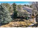Wide exterior shot of home featuring a yard with mature trees, gray siding, and brick accents at 15157 E Louisiana Dr # A, Aurora, CO 80012