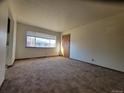 Bright living room with ample natural light, neutral walls and carpeting at 117 Valentine Ln, Longmont, CO 80501