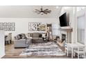 Cozy living room with a fireplace, a ceiling fan, and natural light at 17067 Motsenbocker Way, Parker, CO 80134