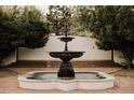 Captivating fountain surrounded by lush greenery and brickwork in this home's idyllic front yard at 3 Carriage Brook Rd, Cherry Hills Village, CO 80121
