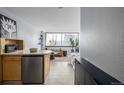 Studio apartment kitchen with light wood cabinets, stainless steel appliances, and a breakfast bar at 1196 N Grant St # 204, Denver, CO 80203