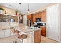 A functional kitchen featuring wood cabinets and an island with bar stool seating at 23584 E 5Th Pl, Aurora, CO 80018