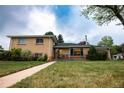 Beautifully kept home with a green lawn, walkway, and charming covered porch, exuding curb appeal at 2592 S Winona Ct, Denver, CO 80219