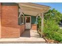 Covered front porch showcasing a white door with a lattice window and brick accents at 815 Hoyt St, Lakewood, CO 80215