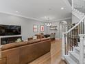 Open-concept living area features a large sofa, hardwood floors, natural lighting, and stairs at 425 Steele St, Denver, CO 80206