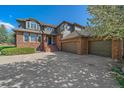 Gorgeous home showcasing a three car garage, brick accents, and manicured landscaping at 73 N Ranch Rd, Littleton, CO 80127