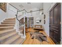 Bright foyer with an open staircase, hardwood floors, and a cozy sitting area, creating an inviting entrance at 73 N Ranch Rd, Littleton, CO 80127