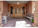 Inviting porch with comfortable seating, stone columns, and a charming entry door at 1034 N Logan St # 2W, Denver, CO 80203