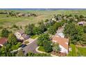 Scenic aerial view of a residential neighborhood nestled among lush green trees and open fields at 5090 Golden Valley Trl, Castle Rock, CO 80109