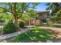 Two-story home with lush landscaping and a large tree at 5178 W Lake Pl, Littleton, CO 80123