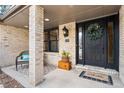 Inviting front porch with brick columns and a charming wreath at 5178 W Lake Pl, Littleton, CO 80123