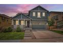 Charming two-story home boasts a well-maintained lawn and a welcoming front porch with stone accents at 10935 Valleybrook Cir, Highlands Ranch, CO 80130