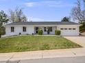 Daytime shot of a charming, updated home with a freshly painted exterior and manicured front yard at 6863 S Detroit Cir, Centennial, CO 80122