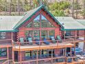 Stunning exterior showcasing decks, a hot tub, and large windows for taking in the picturesque mountain setting at 10268 Christopher Dr, Conifer, CO 80433
