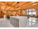 Open kitchen design features modern island, stainless appliances, and wood beamed ceilings at 10268 Christopher Dr, Conifer, CO 80433