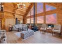 Inviting living room offers a cozy fireplace, soaring ceilings, and expansive windows at 10268 Christopher Dr, Conifer, CO 80433