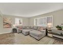 Bright living room featuring a comfortable sectional sofa and large windows at 6431 W Arbor Ave, Littleton, CO 80123