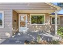 Home features a covered front porch with a wooden door at 4240 Harlan St, Wheat Ridge, CO 80033