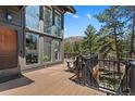 Inviting wooden deck area with stylish railing and views of trees and distant hills at 5090 S Perry Park Rd, Sedalia, CO 80135