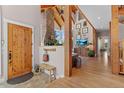 Warm foyer leads to living area with vaulted ceiling, stone fireplace, and hardwood floors at 5090 S Perry Park Rd, Sedalia, CO 80135