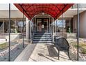 Close-up of building entrance with canopy, brick walkway, double doors, and bench at 2 Adams St # 608, Denver, CO 80206