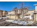 Two-story townhouse with attached garage and snowy landscaping at 3242 S Heather Gardens Way, Aurora, CO 80014