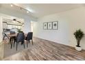 Open concept dining room featuring laminate wood flooring, modern lighting, and three art pieces at 735 S Clinton St # 5B, Denver, CO 80247