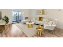 Bright living room with a sliding glass door to a balcony, modern furnishings, and hardwood flooring at 735 S Clinton St # 5B, Denver, CO 80247