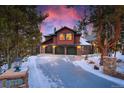 Charming exterior featuring a three-car garage and stone facade with a sky painted in hues of pink and blue at 127 Marks Ln, Breckenridge, CO 80424