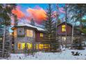 Exterior view displaying a stunning home with stone accents, large windows, and a vibrant sunset sky at 127 Marks Ln, Breckenridge, CO 80424