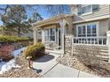 Charming home with stone pillar accents, covered entrance, bench, and landscaped front yard at 9431 Crossland Way, Highlands Ranch, CO 80130