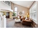 Spacious living room with vaulted ceilings, large windows, and comfortable leather seating at 20304 Vista Cir, Parker, CO 80138