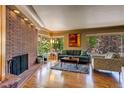 Inviting living room features a unique brick fireplace, hardwood floors, and ample natural light at 9650 W 35Th Ave, Wheat Ridge, CO 80033