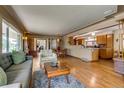 Open-concept living area featuring hardwood floors, modern furnishings, and seamless flow to dining and kitchen at 9650 W 35Th Ave, Wheat Ridge, CO 80033