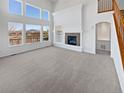 Spacious living room with fireplace, large windows, and neutral tones, creating a bright and inviting space at 23559 Branston Ln, Parker, CO 80138