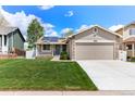 Inviting home featuring a well-kept lawn, stone details, and solar panels for energy efficiency at 13244 Quivas St, Denver, CO 80234