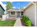Inviting entryway with a charming blue door, solar panels, and manicured landscaping at 13244 Quivas St, Denver, CO 80234