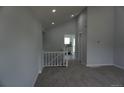 Carpeted living room with vaulted ceiling and open access to other rooms at 8832 Lipan St, Thornton, CO 80260