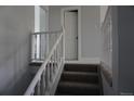 Carpeted staircase with white wood railing leading to the upper level at 8832 Lipan St, Thornton, CO 80260