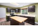 Well-equipped kitchen with stainless steel appliances, central island, and dark cabinetry at 2786 S Cathay Way, Aurora, CO 80013