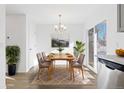 Airy dining room featuring a modern chandelier, a stylish table set, and ample natural light at 317 Pheasant Run, Louisville, CO 80027