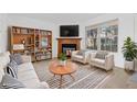 Bright living room with a cozy fireplace, built-in shelves, and modern furnishings at 317 Pheasant Run, Louisville, CO 80027