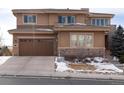 Charming home with a three-car garage, stone accents, and manicured front yard at 10751 Manorstone Dr, Highlands Ranch, CO 80126