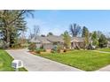 Beautiful home featuring a long driveway, mature trees, pristine landscaping and a well-manicured lawn at 21 Fairway Ln, Littleton, CO 80123