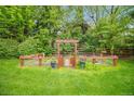 Enclosed garden with an arbor, planting beds, and lush greenery, ideal for cultivating your own produce at 980 E Tufts Ave, Cherry Hills Village, CO 80113