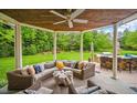 Relaxing outdoor patio with a wicker sectional, ceiling fan, and stone-clad bar, perfect for entertaining at 980 E Tufts Ave, Cherry Hills Village, CO 80113